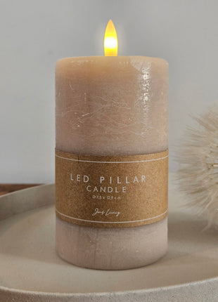 Jens Living LED stompkaars taupe op een keramieke schaal met een kraftpapieren band met opschrift LED Pillar Candle