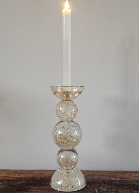 Light & Living kandelaar Itinga L in amber-luster glas met drie gestapelde bollen en een witte LED-kaars op een houten ondergrond