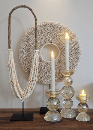Kandelaar Itinga van Light & Living in helder glas met luchtbellen op een luster in amber in een sfeervolle interieuromgeving met warme kaarsverlichting