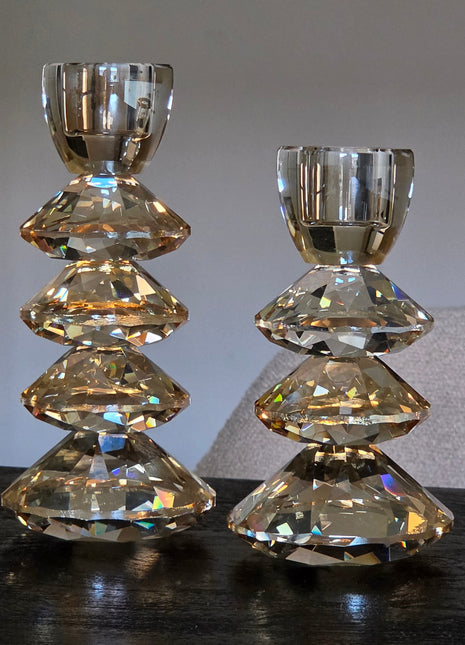 Set kandelaars Rovelo van Light & Living in amber kristalglas in drie maten op een donker houten oppervlak