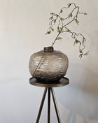 Vaas Gazzo grijs glas gepresenteerd op dressoir met droogbloemen