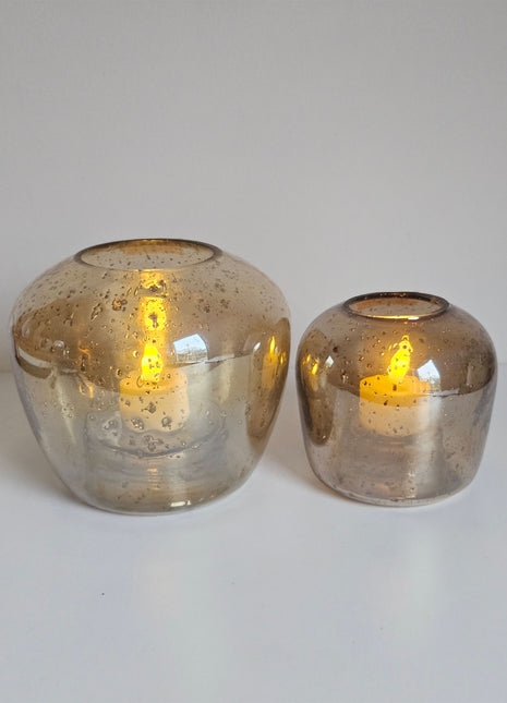 Waxinelichthouders Capira bruin grijs glas gepresenteerd op dienblad met warme ambiance