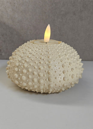 Waxinelichthouder Sea Urchin crème gepresenteerd op dienblad met kaarslicht