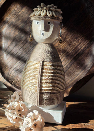 Vooraanzicht van beige Namji Doll Naya met houten gezicht en touw en kralen op een houten tafel voor een dienblad