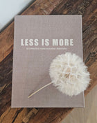 Opbergboek Less is More met lichtgrijze stoffen kaft en witte letters op een witte ondergrond