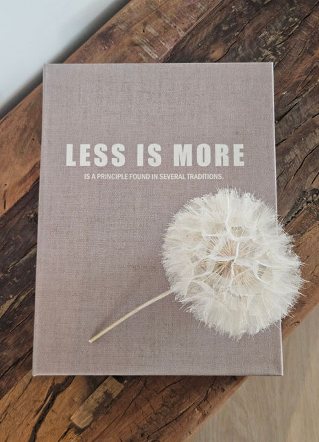 Opbergboek Less is More met lichtgrijze stoffen kaft en witte letters op een witte ondergrond
