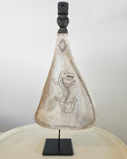 Lepel ornament naturel met gegraveerde draak op een zwarte metalen standaard op een houten ondergrond