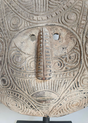 Close-Up Ornament van een gezicht uitgesneden uit hout in de vorm van een masker.