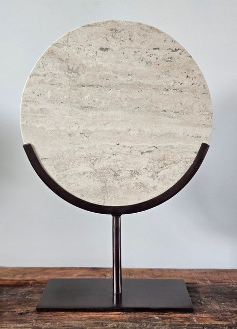 Light & Living ornament op standaard Moreno Travertin in beige-grijs op een zwarte metalen standaard met een kralenketting op een houten ondergrond
