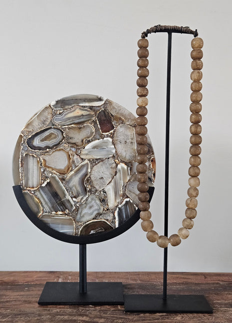 Light & Living ornament op voet Gouya Agaat met agaatschijven in grijs en bruin op een zwarte metalen voet met een kralenketting op een houten ondergrond