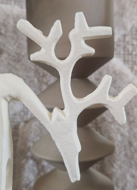 Close-up van het gewei van een mat crème rendierornament met vertakte takken en een matte structuur