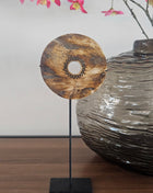 Ronde houten schijf bruin naturel met gegraveerd zonmotief op een zwarte metalen standaard