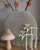 Mat crème rendierornament maat S voor een ribbelvaas met droogbloemen en een paddenstoel ornament op een houten ondergrond