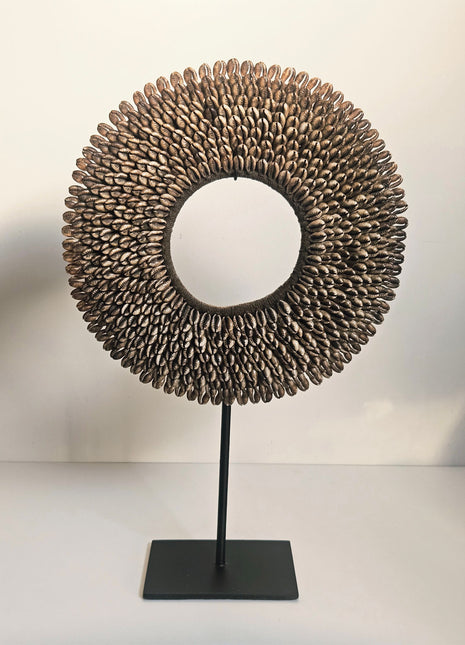 Ronde schelpenketting op standaard met bruine schelpen in koffiekleur. 