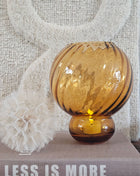 Close-up van de bolle amberkleurige glazen vorm en gedraaide ribbels van een vaas amber glas Ø17 x H20 cm