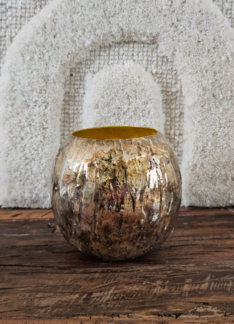 Bolvaas goud metaal M met ruwe gegraveerde buitenkant en goudkleurige binnenkant op een houten ondergrond voor een wit linnen wandpaneel