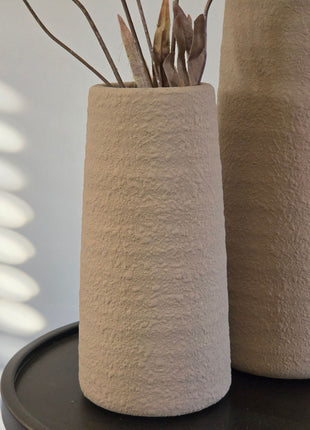 Close-up van beige Elora S vaas met korrelige afwerking en bruine kunsttakken naast grotere vaas op zwart tafeltje