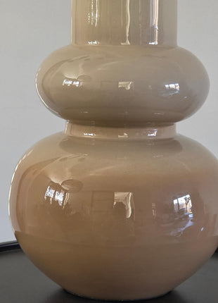 Close-up van taupe Livana vaas met glanzende ronde vormen en lichtreflecties op een zwart tafeltje