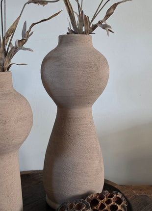 Vooraanzicht van taupe Marconne vaas met ruwe afwerking en beige kunstbloemen naast lotus op een houten dienblad
