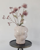 Vaas organisch zand aardewerk met natuurlijke vorm hoogte 22.5cm getoond op een bijzettafel. De vaas heeft kleurrijke bloemen.