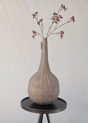 Vaas stone-look oker metaal met organische vorm en natuurlijke afwerking hoogte 35 cm getoond op een bijzettafel. De vaas heeft kleurrijke bloemen.