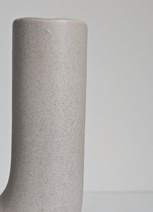 Close-up van vaas U vorm grijs aardewerk - sculpturale vorm en natuurlijke tinten