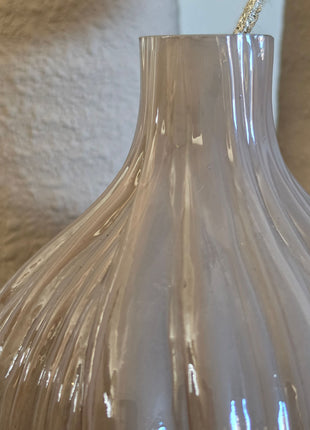 Close-up van taupe-bruine Velin vaas met glanzende ribbels en goudkleurige kunsttak voor beige vazen