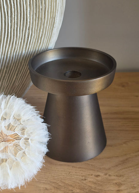 Close-up van bronzen metalen kandelaar Viedma S zonder kaars op houten tafel