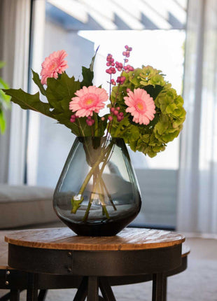 Vrijstaande druppelvormige vaas Tasman S van Vase the World in glanzend taupe glas gestileerd met kleurijke bloemen
