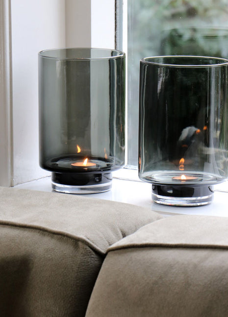 Vase the World waxinelichthouder Thames in een prachtige grijze kleur. De waxinelichthouder is gemaakt van glas en is mondgeblazen. Afgebeeld als een set van twee in een vensterbank hoge conische vorm.