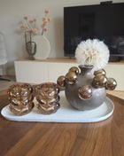 Waxinelichthouder Bubble taupe als onderdeel van een complete interieurset op een houten tafel