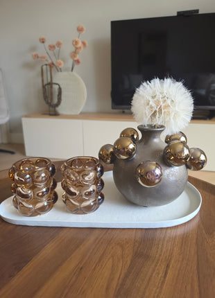 Waxinelichthouder Bubble taupe als onderdeel van een complete interieurset op een houten tafel