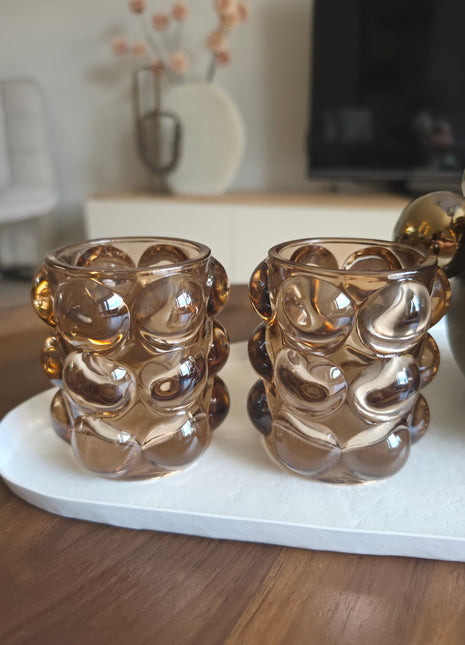 Twee waxinelichthouders Bubble taupe naast elkaar op een houten ondergrond