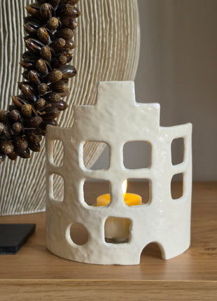 Waxinelichthouder House off-white op een dressoir met brandend waxinelichtje