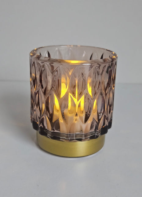 Close-up van waxinelichthouder roze glas - gouden voet en elegante afwerking
