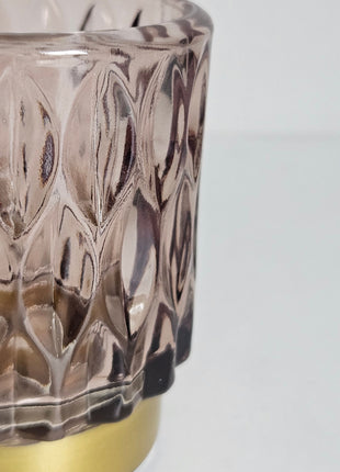 Close-up van waxinelichthouder roze glas met gouden voet - romantische gloed