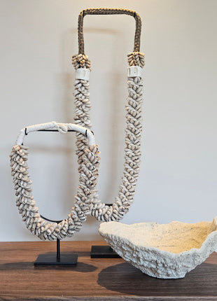Interieur Set Coral met een Light en Living koraal ornament in crème en twee beige schelpenkettingen op standaard.