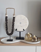 Woonaccessoire Set Ivory Bloom met een wit ringsteen ornament, bruine schelpenketting en twee Capira waxinelichthouders op ivoor dienblad.