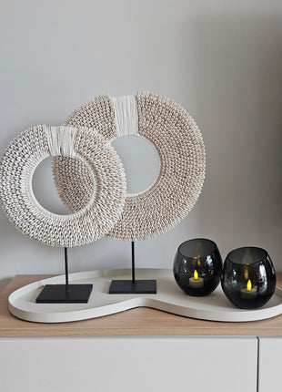 Woonaccessoire Set Ivory Class met twee wit-beige schelpenkettingen en twee grijze Moho waxinelichthouders op een ivoorkleurig dienblad.