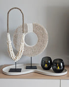 Decoratie Set Ivory Icon met twee verschillende wit-beige schelpenkettingen en twee grijze Moho waxinelichthouders op ivoor dienblad.