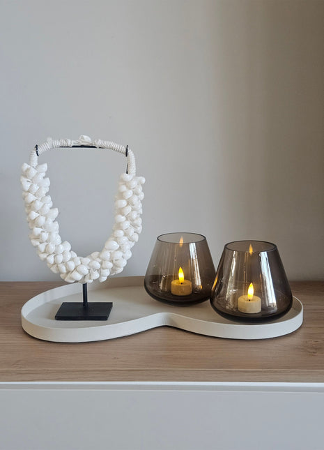 Woonaccessoire Set Ivory Lumi met een natuurlijk witte schelpenketting en twee taupe Tasman waxinelichthouders op een ivoor dienblad.