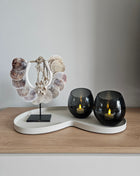 Woonaccessoire Set Ivory Parelmoer met een parelmoer schelpenketting en twee grijze Moho waxinelichthouders op een ivoorkleurig dienblad.