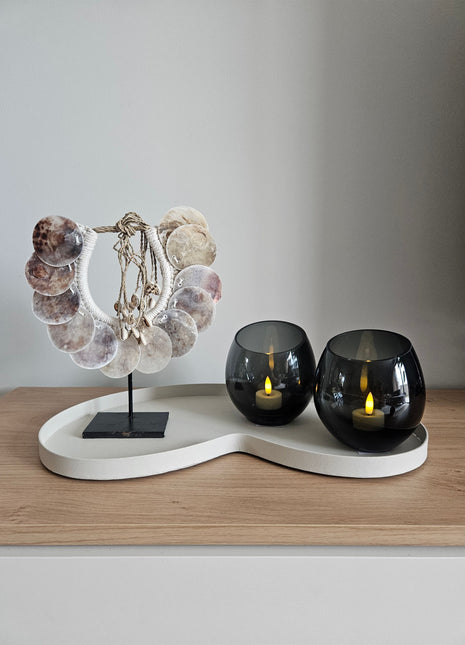 Woonaccessoire Set Ivory Parelmoer met een parelmoer schelpenketting en twee grijze Moho waxinelichthouders op een ivoorkleurig dienblad.