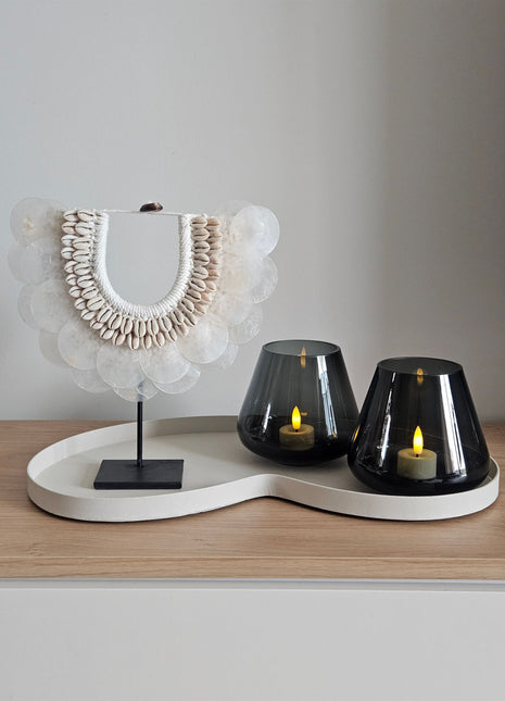 Woonaccessoire Set Ivory Sand met een witte schelpenketting op standaard en twee grijze Tasman waxinelichthouders op een ivoor dienblad.
