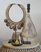 Decoratie Set Taupe Deluxe met een lepel ornament met draak, een tijgerschelp ketting en een taupe Tasman waxinelichthouder op dienblad.