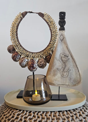 Decoratie Set Taupe Deluxe met een lepel ornament met draak, een tijgerschelp ketting en een taupe Tasman waxinelichthouder op dienblad.