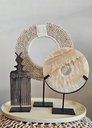 Woonaccessoire Set Taupe Onyx met een beige onyx natuursteen ornament, houten kam en wit-beige schelpenketting op taupe dienblad.