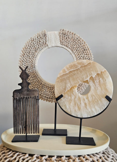 Woonaccessoire Set Taupe Onyx met een beige onyx natuursteen ornament, houten kam en wit-beige schelpenketting op taupe dienblad.
