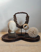 Woonaccessoire Set Walnut Comfort met een houten hoofd ornament, onyx schijf, paardenbloem en bruine schelpenketting op walnoot dienblad.