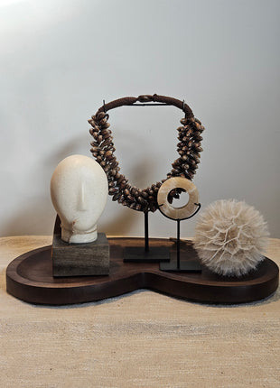 Woonaccessoire Set Walnut Comfort met een houten hoofd ornament, onyx schijf, paardenbloem en bruine schelpenketting op walnoot dienblad.